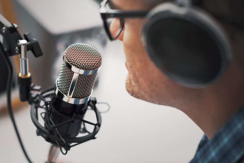 Man speaking to a podcasting microphone